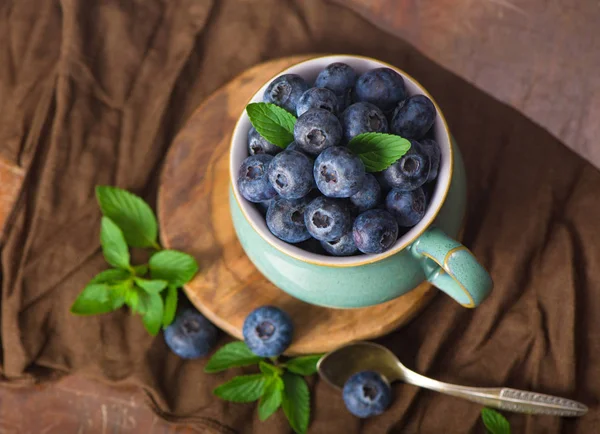 Frische Blaubeeren in einer Tasse mit Minzblättern — Stockfoto