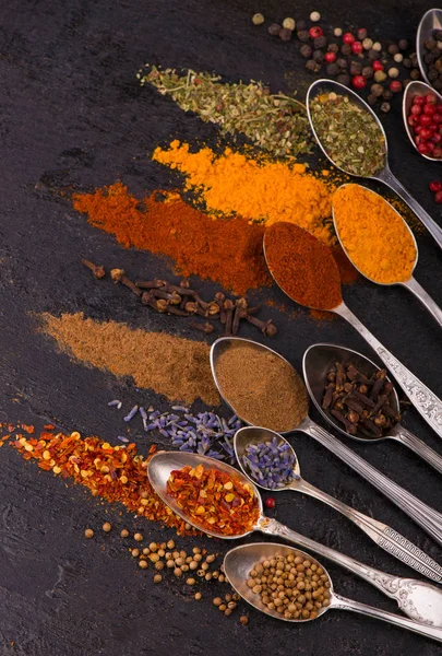 Spices and condiments for cooking on a black background — Stock Photo, Image