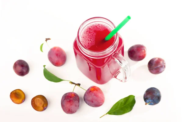 Švestková šťáva ve sklenici s čerstvým švestkovým ovocem izolované na bílém pozadí — Stock fotografie