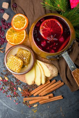 Sıcak şarap, mavi çam ağacı dalı ve ahşap arka planda baharatlar.