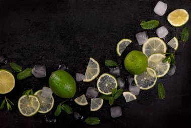 Siyah arka planda taze nane, kireç ve buz. Mahito 'nun malzemesi. Üst görünüm