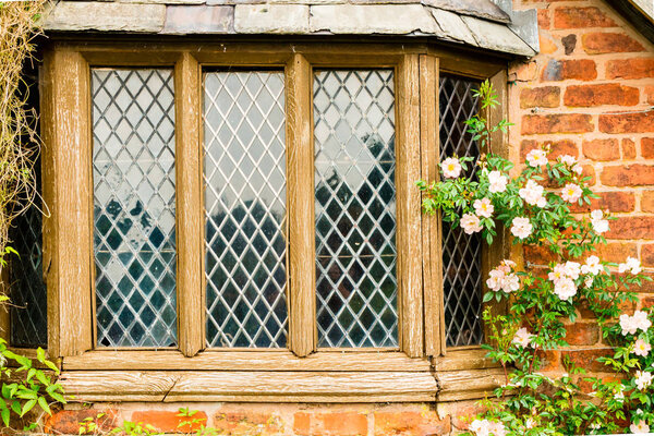 Old weathered leaded window of a garden house.