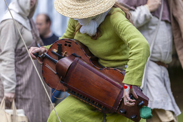 Female musician with antique musical instrument at Medieval Fayre.