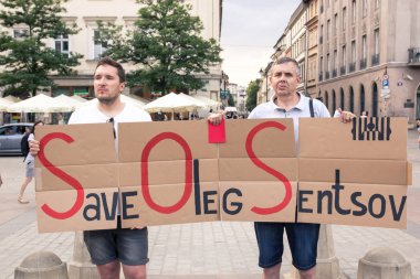 Krakow, Polonya, 01 Haziran 2018, Rusya,'siyasi tutukluları karşı protesto bir posteri ile iki adam kaydetmek Oleg sentsov