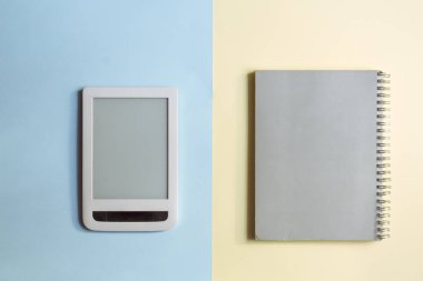 Elektronik tablet ve mavi ve sarı pastel arka üstünde Kağıt defter, eski ve yeni arasında çatışma kavramı