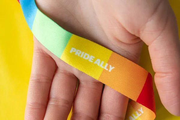 LGBT symbol - hand with rainbow ribbon and pride ally, the conce