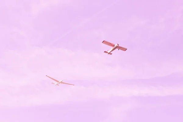 Malé jednomotorové staré roční letadlo a kluzák plující proti — Stock fotografie