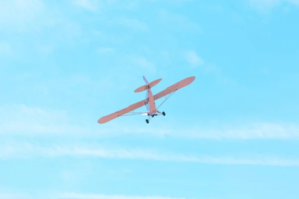 Маленький одномоторный старинный самолет, летящий против синего неба — стоковое фото