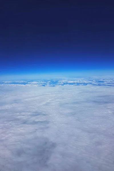 Baixa órbita terrestre - Vista de nuvens brancas e montanhas durante o voo para a órbita baixa da Terra, no topo do céu azul e espaço — Fotografia de Stock
