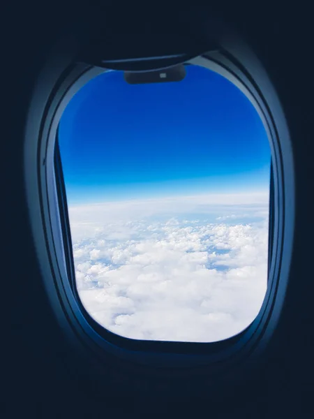 Вид из окна самолета на облака и небо во время полета — стоковое фото