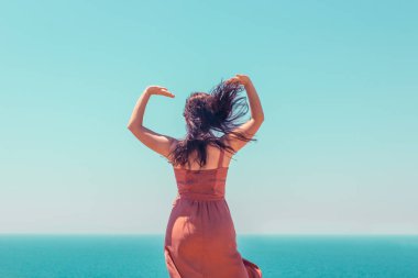 Bir arka plan üzerinde dans bir yaz kahverengi elbiseli genç bir kız 