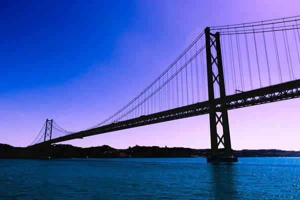 Siluet jembatan logam besar di seberang laut — Stok Foto
