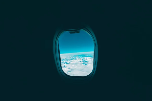 Вид из окна самолета на облака и бледно-голубое небо — стоковое фото