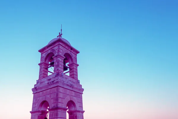 Creative surreal purple bell tower on blue sky background — Stock Photo, Image