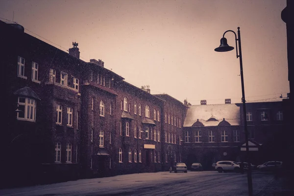 First snow falls on old vintage brick houses