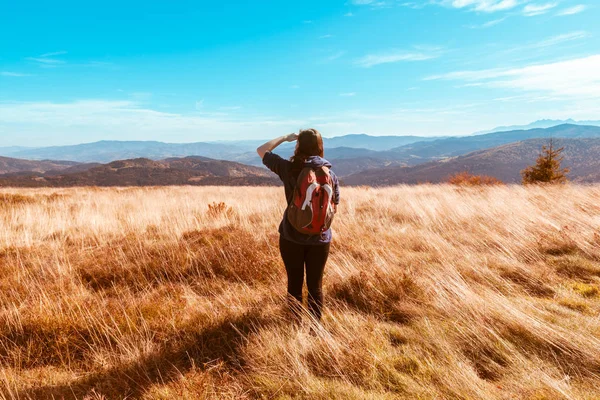 Ein Mädchen in einer Jacke mit Kapuze und einem Rucksack sieht aus Stockbild