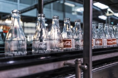 LAUNDA/ANGOLA - 23 MAY 2018 - coca cola factory, ready-to-fill bottles on the line. clipart