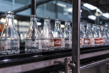 LAUNDA/ANGOLA - 23 MAY 2018 - coca cola factory, ready-to-fill bottles on the line. clipart