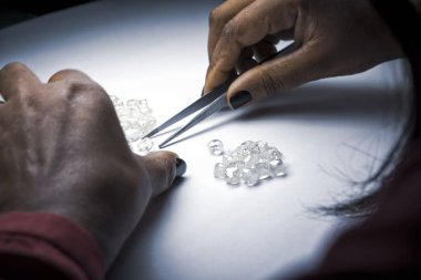 Kadının teftiş yapan pürüzlü elmas forseps ile eller..