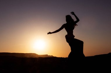 Kanyonlar ile Namibe çölde gün batımı ile ünlü oryantal dans için dans kadın silüeti. Afrika. Angola.