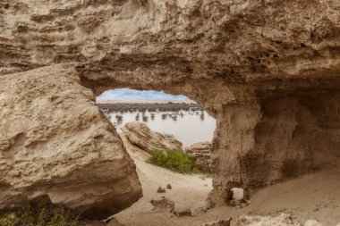 View of the oasis of the Namibe Desert, through the arch. Angola. Africa. clipart