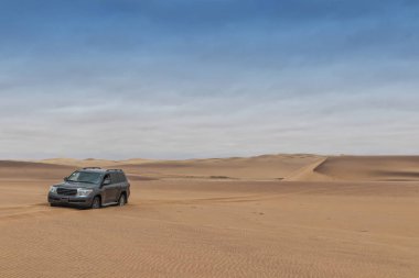 car stuck in the desert sand of Namibe. Africa. Angola. clipart
