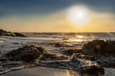 Güzel gün batımı ıssız Namibe sahilde. Fotoğraf cliff ve kayalar suyla tarafından çekilmiştir. Afrika. Angola.