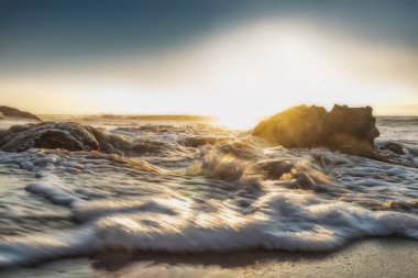 Güzel gün batımı ıssız Namibe sahilde. Fotoğraf cliff ve kayalar suyla tarafından çekilmiştir. Afrika. Angola.