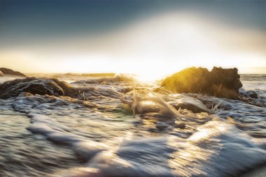 Güzel gün batımı ıssız Namibe sahilde. Fotoğraf cliff ve kayalar suyla tarafından çekilmiştir. Afrika. Angola.