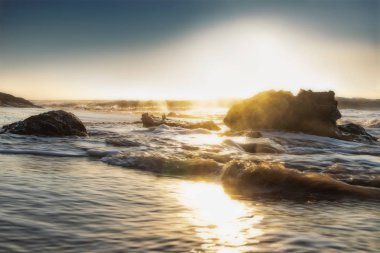 Güzel gün batımı ıssız Namibe sahilde. Fotoğraf cliff ve kayalar suyla tarafından çekilmiştir. Afrika. Angola.