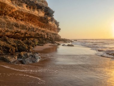 Güzel gün batımı sahilde Namibe vahşi Afrika. Angola. Cliff ve kayalar.