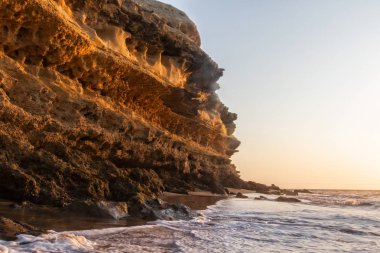 Güzel gün batımı sahilde Namibe vahşi Afrika. Angola. Cliff ve kayalar.