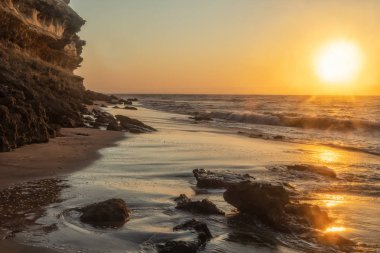 Güzel gün batımı sahilde Namibe vahşi Afrika. Angola. Cliff ve kayalar.