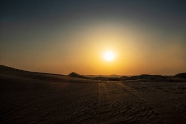 Çöl, yatay, Abu Dabi günbatımı ve lastik kuma izler. Birleşik Arap Emirlikleri.