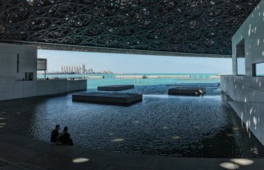 BAE / Abudhabi - 18 Dez 2018 - Abu Dabi Louvre Müzesi atrium oturan çift. Birleşik Arap Emirlikleri.