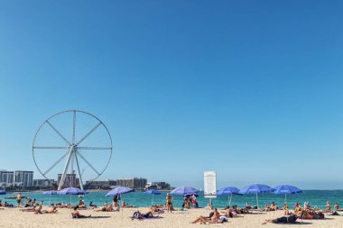 BAE / Dubai - dönme dolap ve turistler ile 20 Dez 2018 - Dubai Beach'te güneşlenirken.