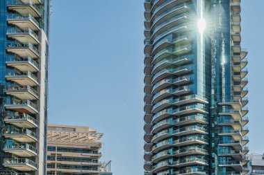 Mavi gökyüzü ve güneş pencereye yansıyan gökdelenler görüntüleyin.