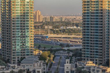 Mavi gökyüzü ve güneş pencereye yansıyan gökdelenlerin görünümü. Gün batımı ışığıyla. Uçan