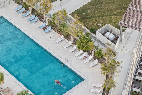 Fotografia aérea do homem nadando na piscina com água azul . — Fotografia de Stock