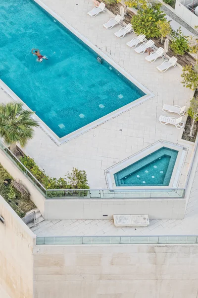 Fotografia aerea dell'uomo che nuota in piscina con acqua blu . — Foto Stock