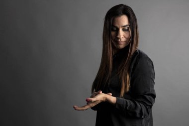 Orta yaşlı kadının Etkileyici Portresi, gri yönetici arka planlı yarı vücut.