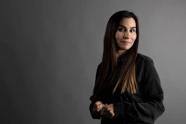 Orta yaşlı kadın portresi, gri yönetici arka plan ile yarım vücut.