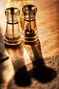 ahşap masa ve doğal ışık üzerine tuz ve biber ile cruet.