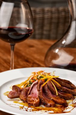 Yukarıdan görülen biftek güzel tabak. Bir bardak kırmızı şarap ile