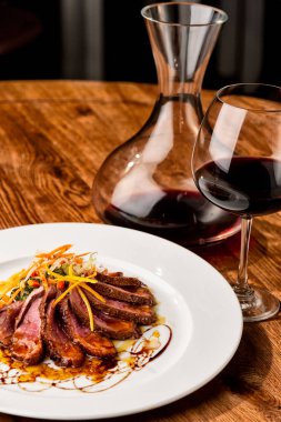 Yukarıdan görülen biftek güzel tabak. Bir bardak kırmızı şarap ile