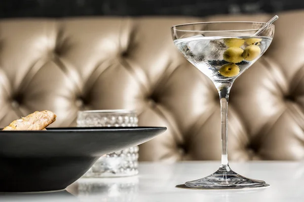 Beau verre de martini aux olives accompagné d'un plat gastronomique . — Photo