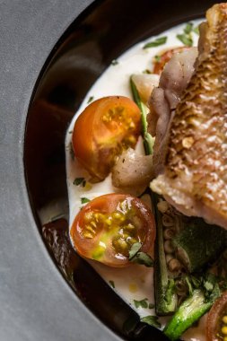 Kızarmış balık keabos ve domates yukarıdan görülen eşlik ediyor. Gurme yemek.