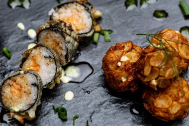 Sushi Roll yukarıdan görüntülendi. Siyah taş üzerinde.
