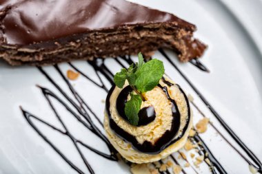 Çikolata tepesi ve çikolatalı kek dilim ile sarı dondurma topu. Gurme tatlı oluşturma.