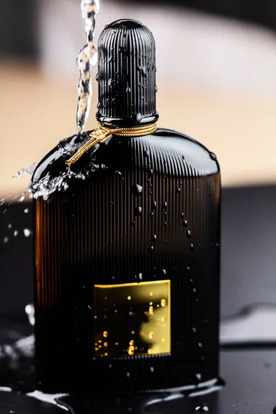 Bela fotografia de produto de perfume preto com respingo de água . — Fotografia de Stock